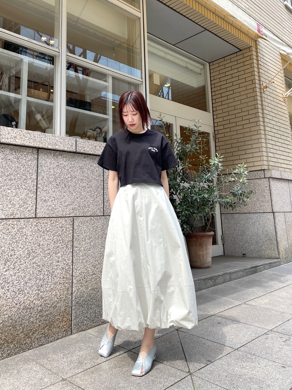 シルバー系のパンプス、ブラック系のTシャツ/カットソー、ホワイト系のスカートを着用したレディースの春コーディネートの2枚目の写真