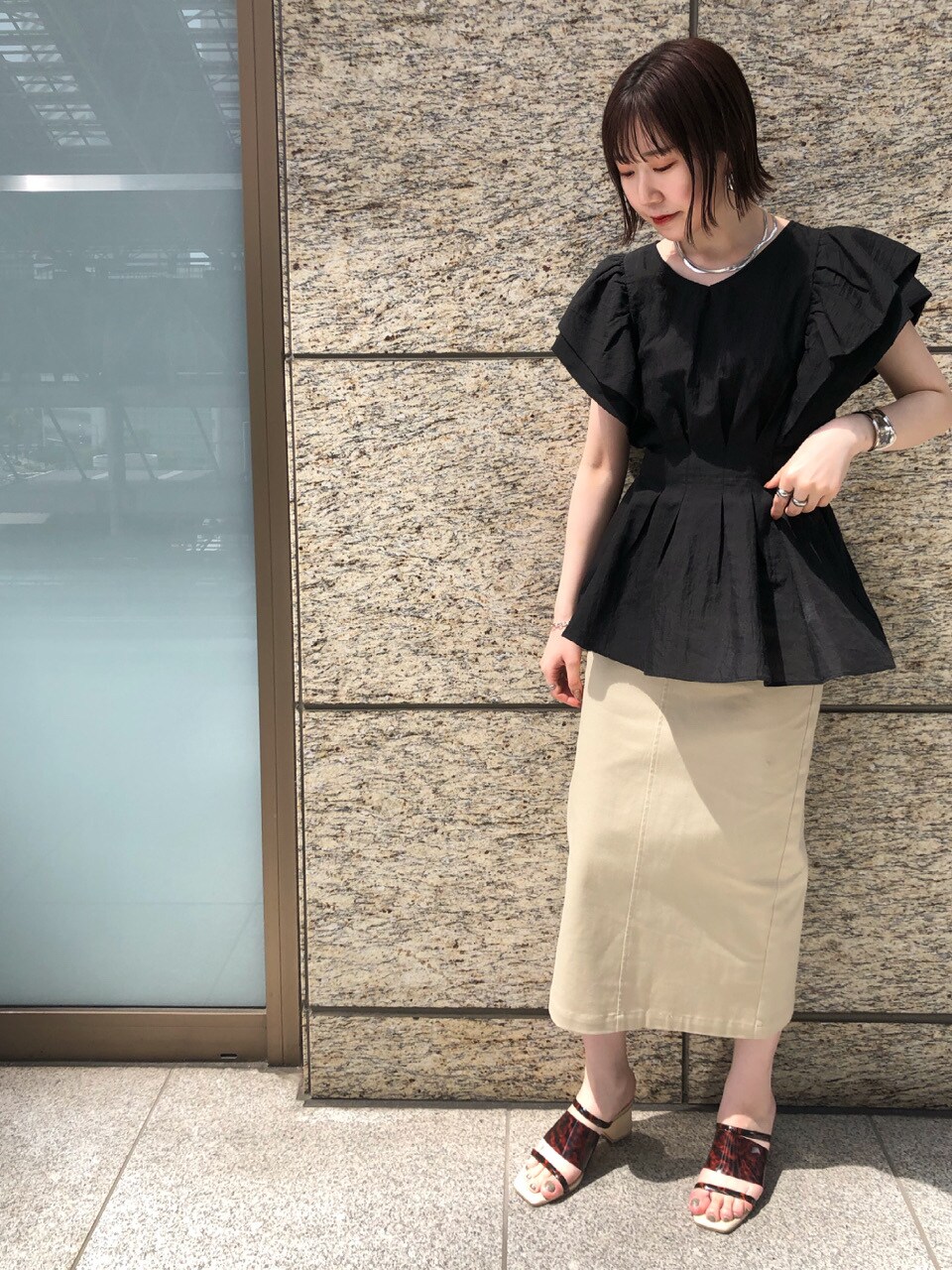 ブラック系のシャツ/ブラウス、ベージュ系のスカート、その他のその他シューズを着用したレディースの春コーディネートの4枚目の写真