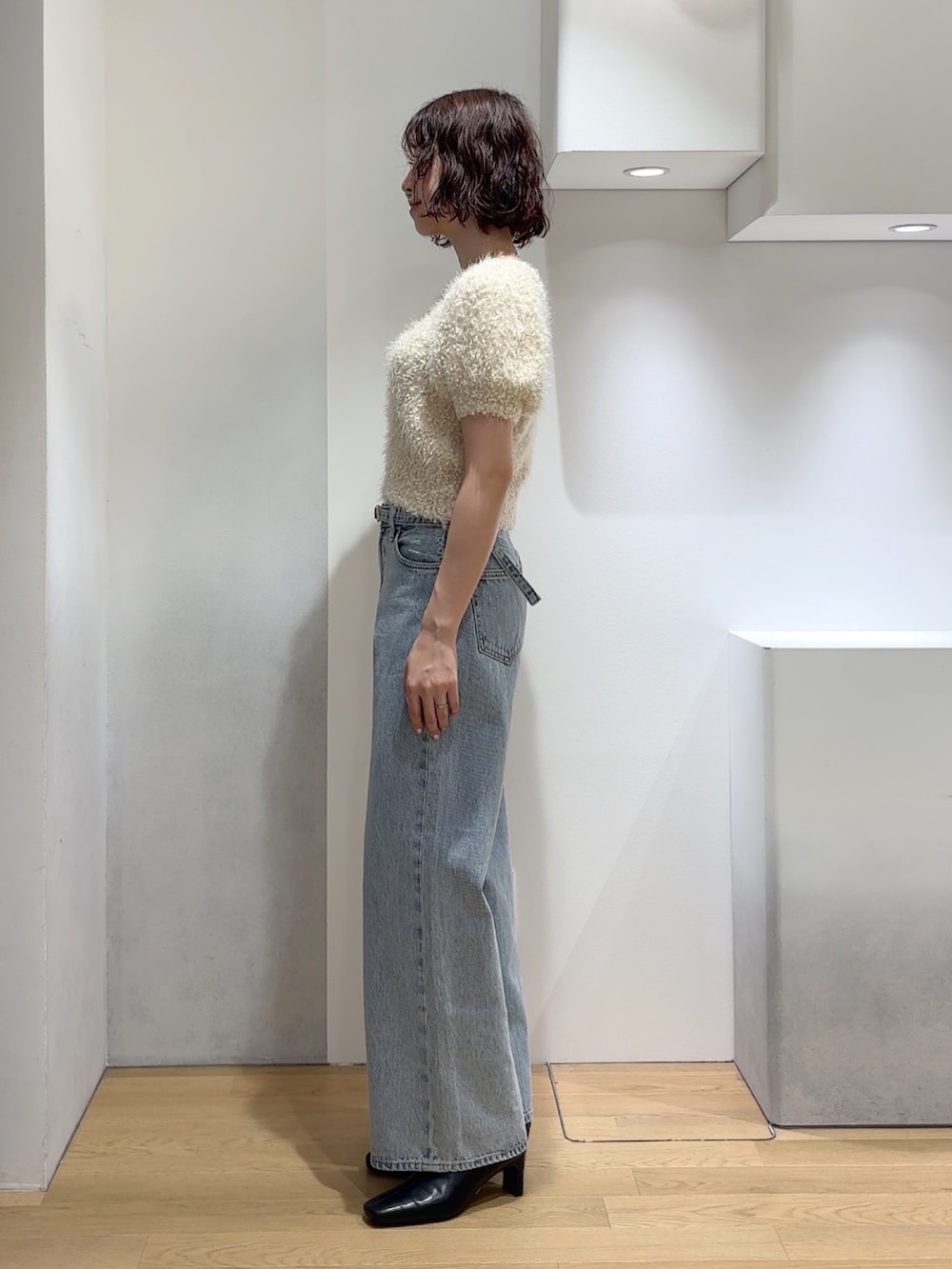 ホワイト系のニット/セーター、ブルー系のデニムパンツ、ブラック系のブーツを着用したレディースの秋コーディネートの8枚目の写真