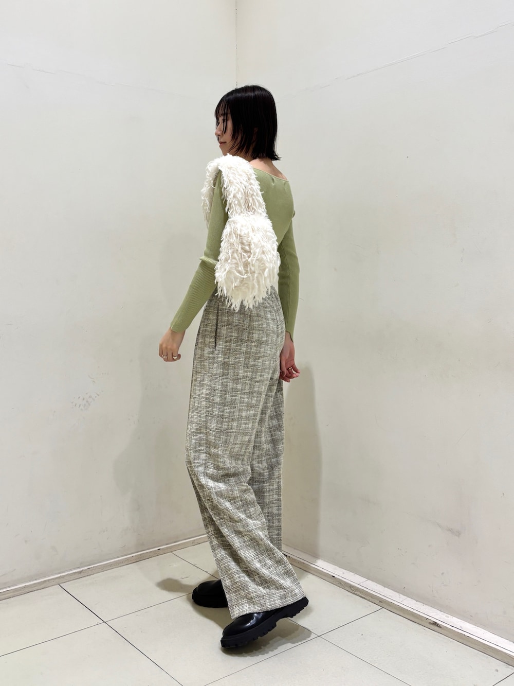 ホワイト系のその他パンツ、グリーン系のニット/セーター、ホワイト系のハンドバッグを着用したレディースの冬コーディネートの3枚目の写真
