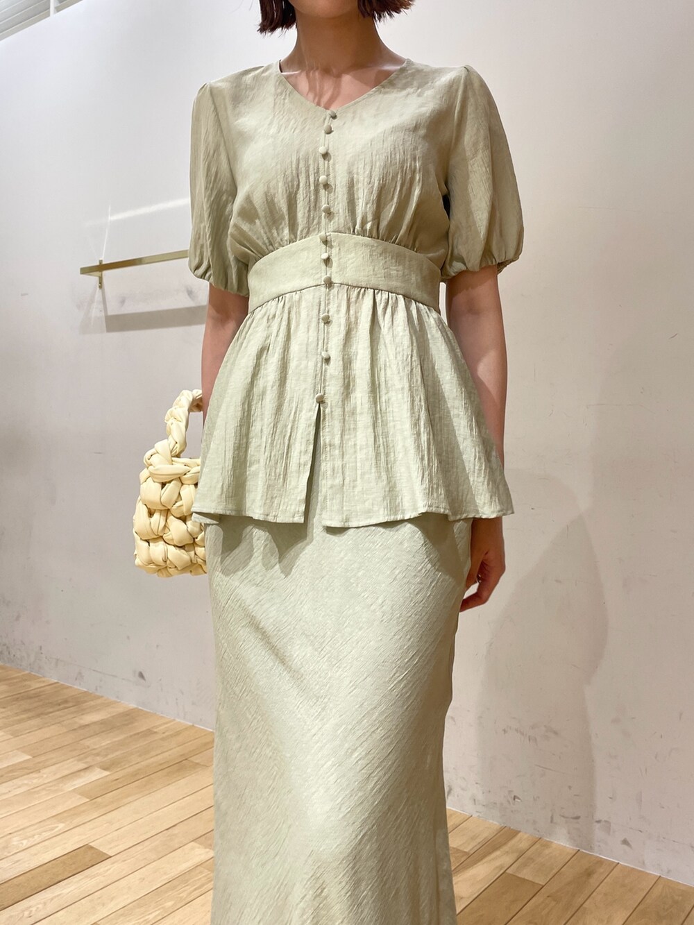 ベージュ系のハンドバッグ、ブラック系のサンダル、グリーン系のスカートを着用したレディースの夏コーディネートの6枚目の写真