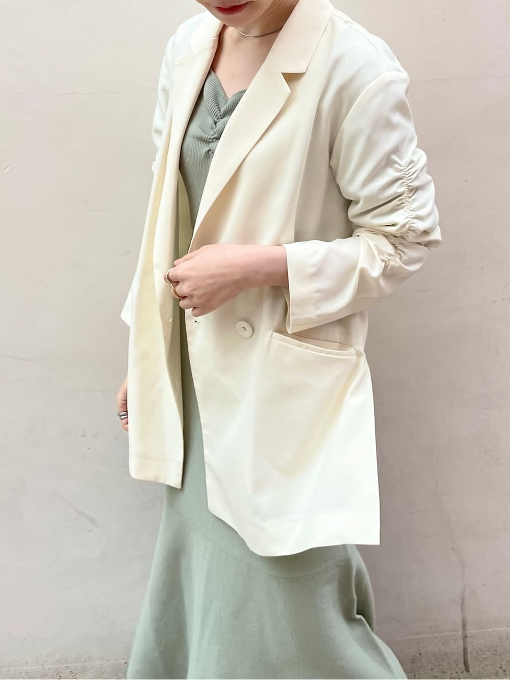 ブラック系のその他シューズ、ホワイト系のテーラードジャケット、グリーン系のワンピースを着用したレディースの冬コーディネートの5枚目の写真