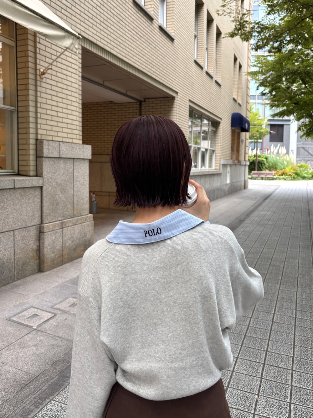 ブラウン系のスカート、グレー系のニット/セーター、イエロー系のハンドバッグを着用したレディースの秋コーディネートの6枚目の写真