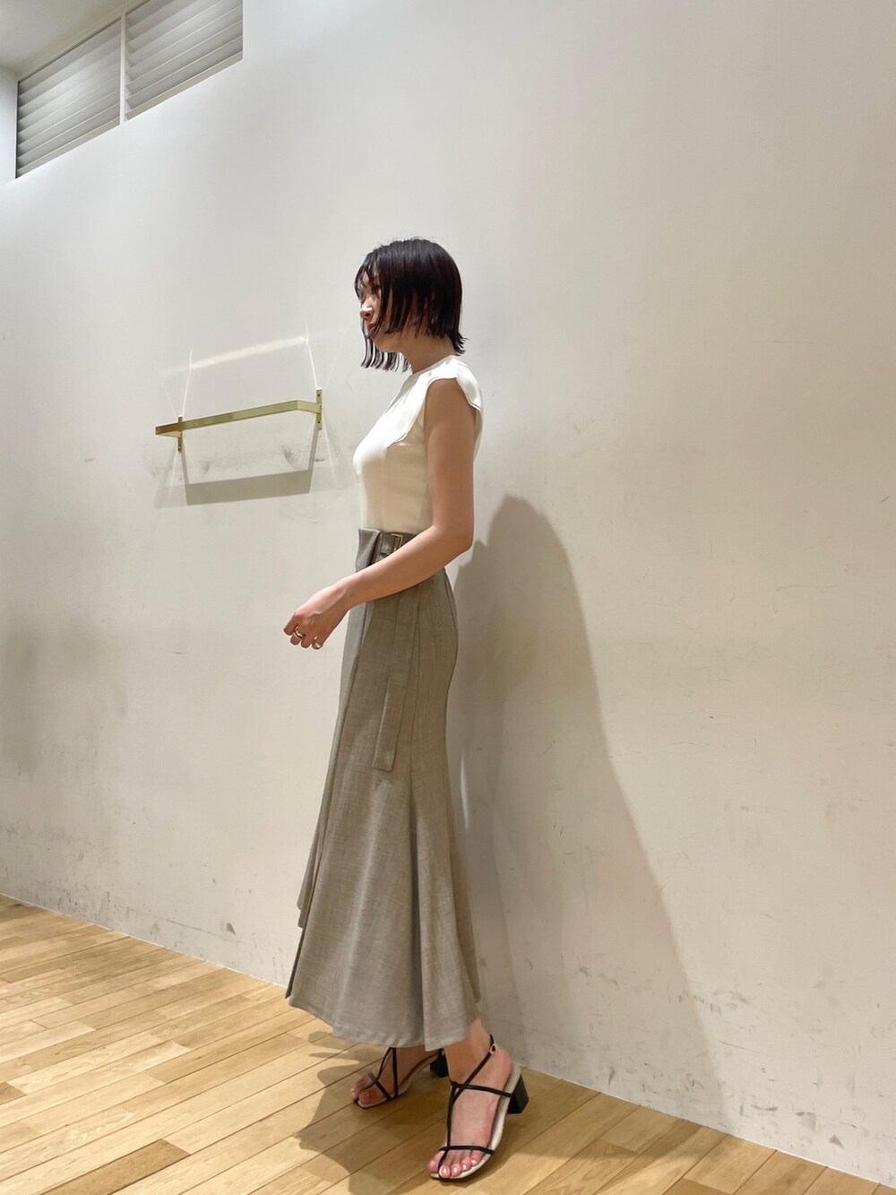 イエロー系のサンダル、ベージュ系のスカート、ホワイト系のニット/セーターを着用したレディースの夏コーディネートの4枚目の写真