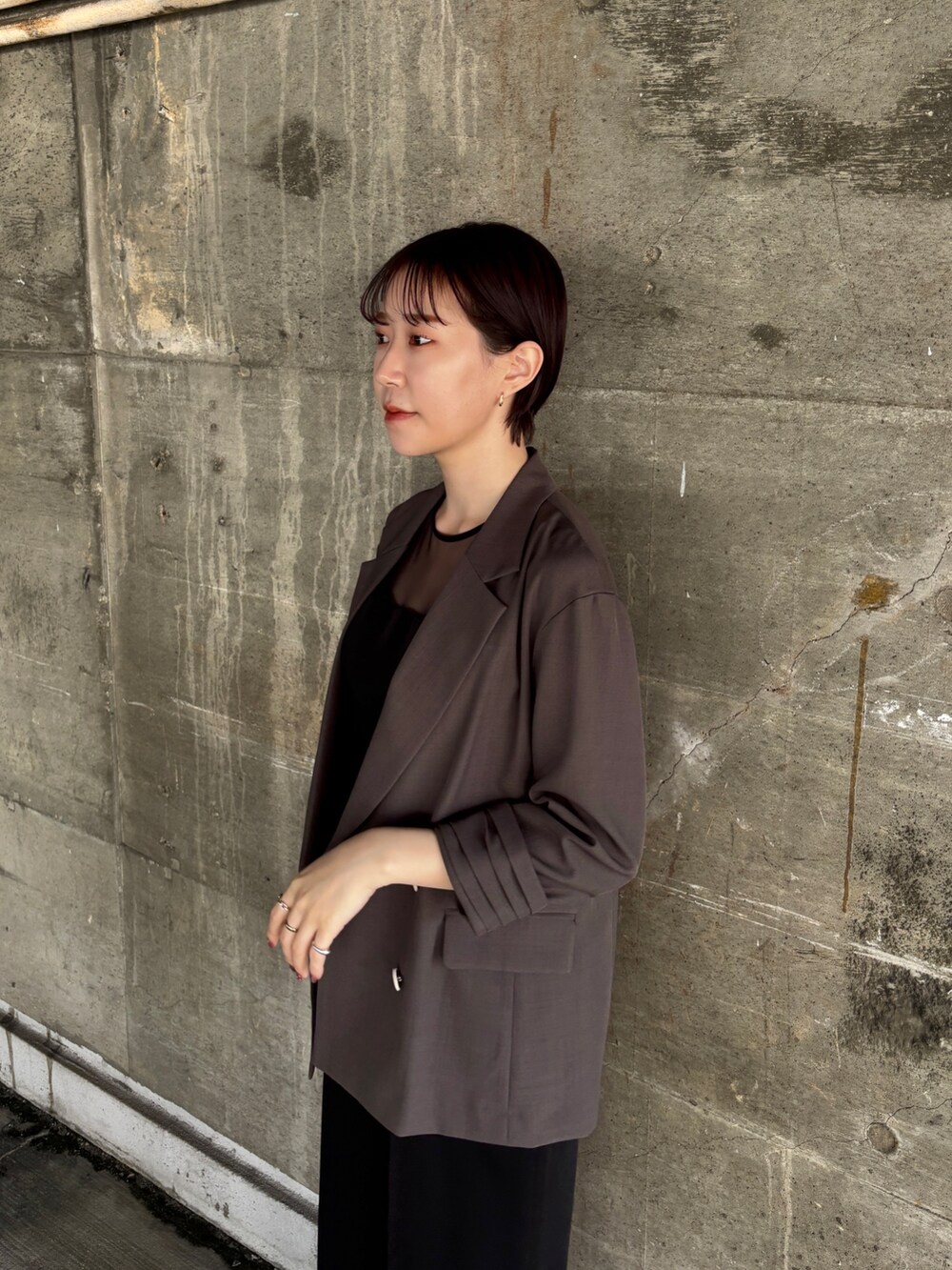 グレー系のテーラードジャケット、ブラック系のパンツドレス、その他のパンプスを着用したレディースの春コーディネートの6枚目の写真