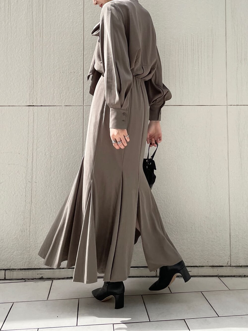 ブラック系のその他シューズ、ホワイト系のその他アウター、ブラウン系のシャツ/ブラウスを着用したレディースの冬コーディネートの3枚目の写真