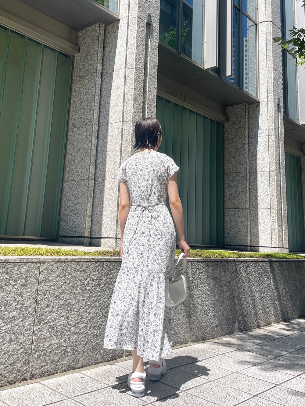 ホワイト系のワンピース、ホワイト系のハンドバッグを着用したレディースの夏コーディネートの8枚目の写真