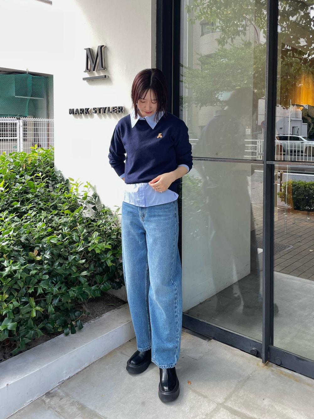 ブルー系のデニムパンツ、ブラック系のブーツ、ブルー系のニット/セーターを着用したレディースの秋コーディネートの2枚目の写真