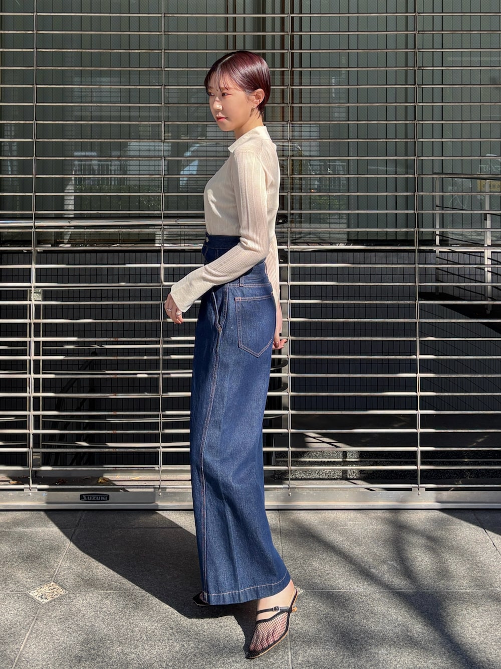 ホワイト系のTシャツ/カットソー、ブラック系のサンダル、ブルー系のデニムパンツを着用したレディースの春コーディネートの2枚目の写真