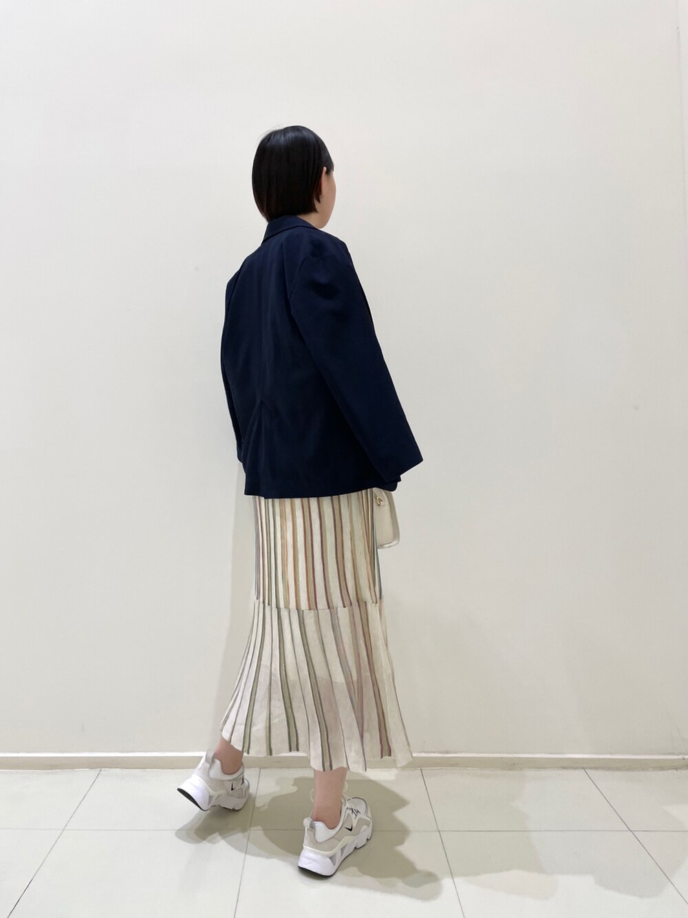 ブルー系のテーラードジャケット、ホワイト系のワンピース、ホワイト系のショルダーバッグを着用したレディースの春コーディネートの5枚目の写真