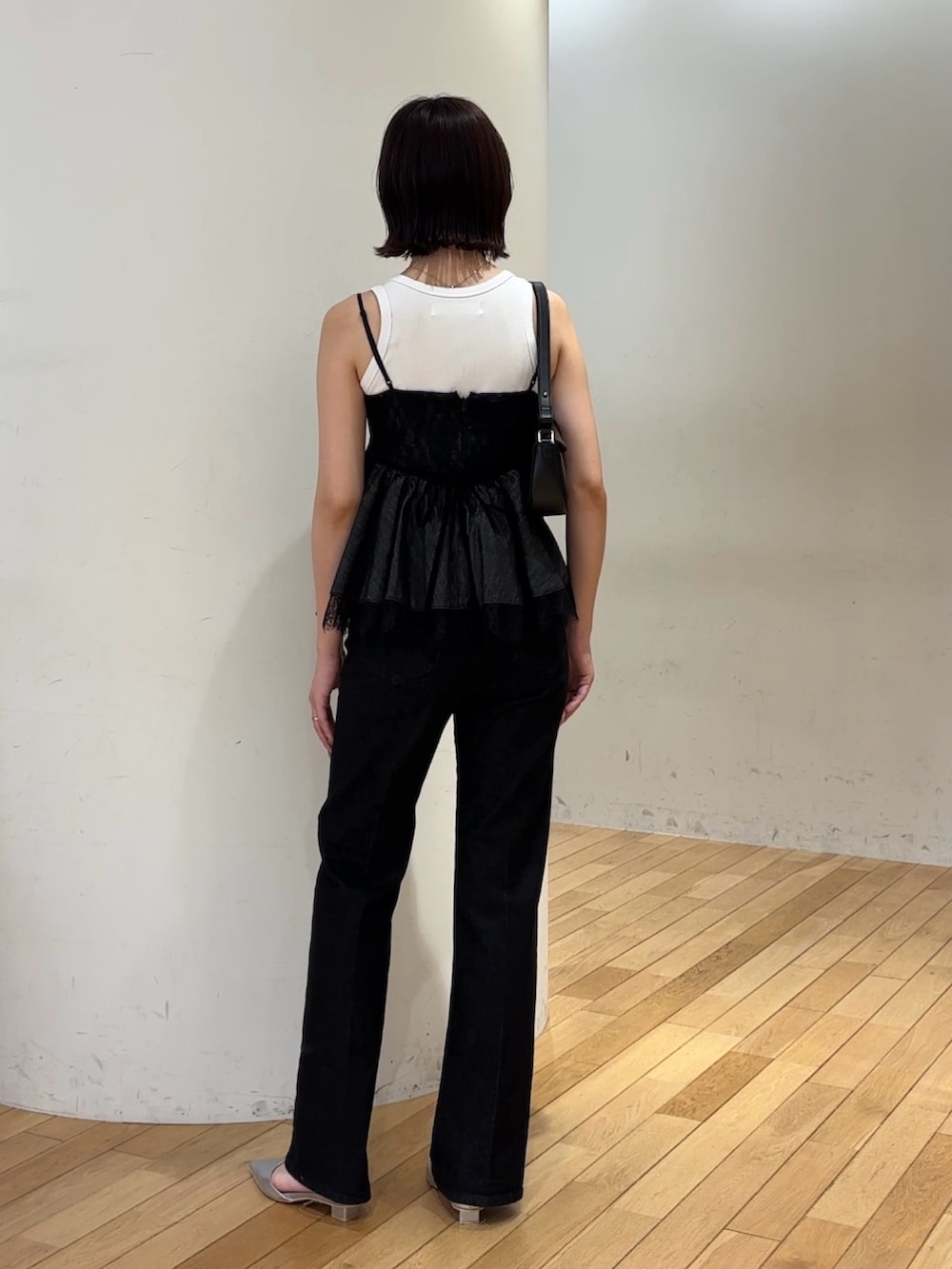 ブラック系のデニムパンツ、シルバー系のパンプス、ホワイト系のタンクトップを着用したレディースの夏コーディネートの3枚目の写真