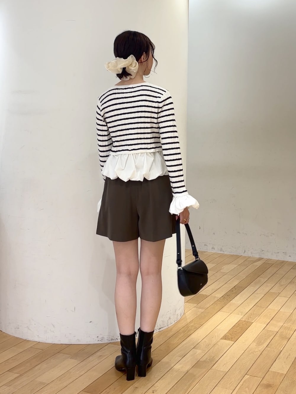 ブラウン系のその他パンツ、ブラック系のハンドバッグ、ブラック系のブーツを着用したレディースの夏コーディネートの4枚目の写真