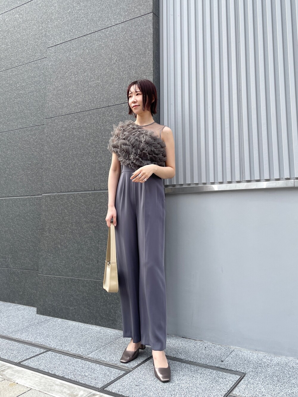 その他のパンプス、グレー系のパンツドレス、ベージュ系のハンドバッグを着用したレディースの春コーディネートの5枚目の写真