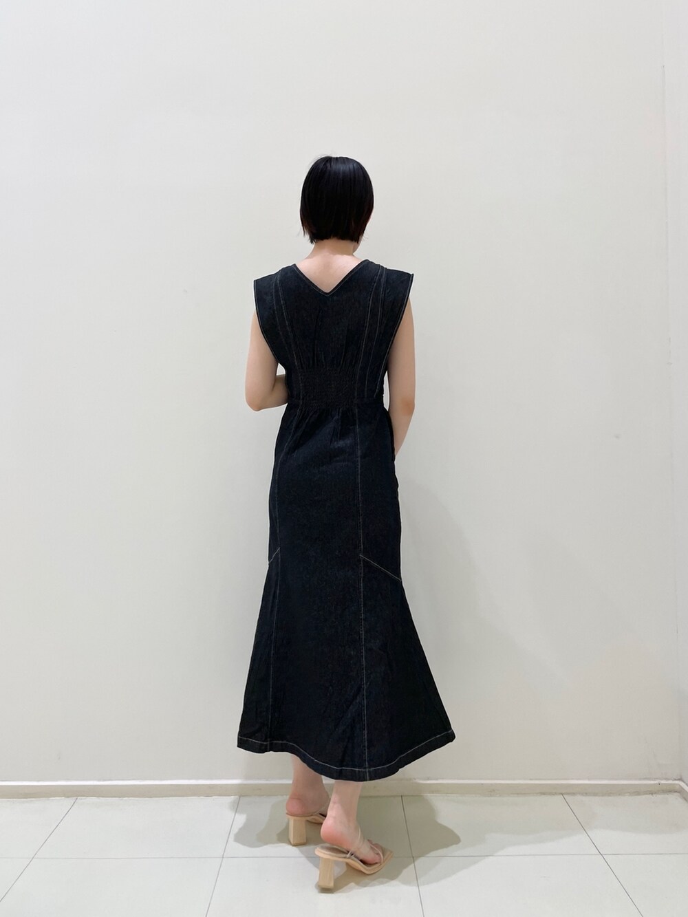 ブラック系のワンピース、ベージュ系のカーディガン/ボレロ、その他のサンダルを着用したレディースの春コーディネートの4枚目の写真