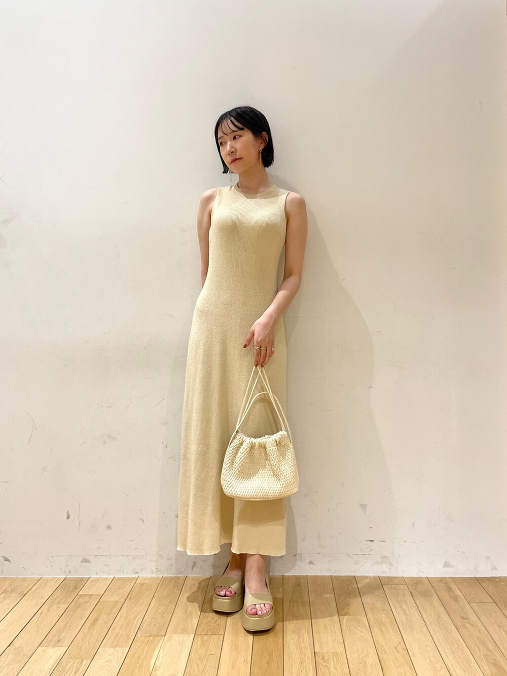 ベージュ系のワンピース、ブラウン系のハンドバッグ、ベージュ系のサンダルを着用したレディースの夏コーディネートの6枚目の写真