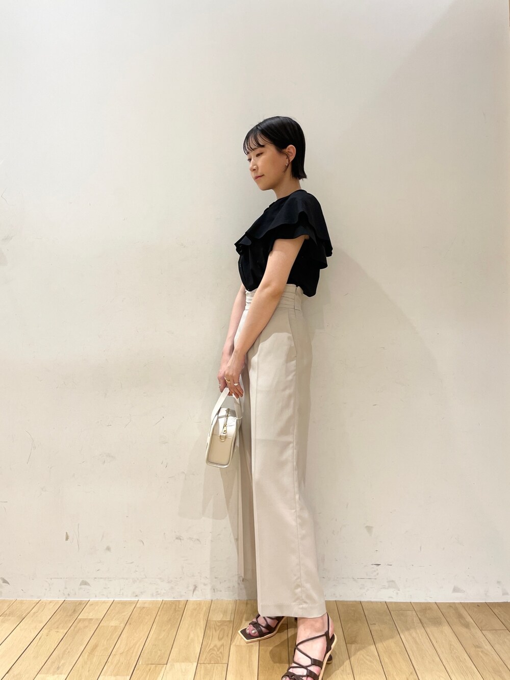 ブラック系のシャツ/ブラウス、ホワイト系のスラックス、ホワイト系のショルダーバッグを着用したレディースの夏コーディネートの5枚目の写真
