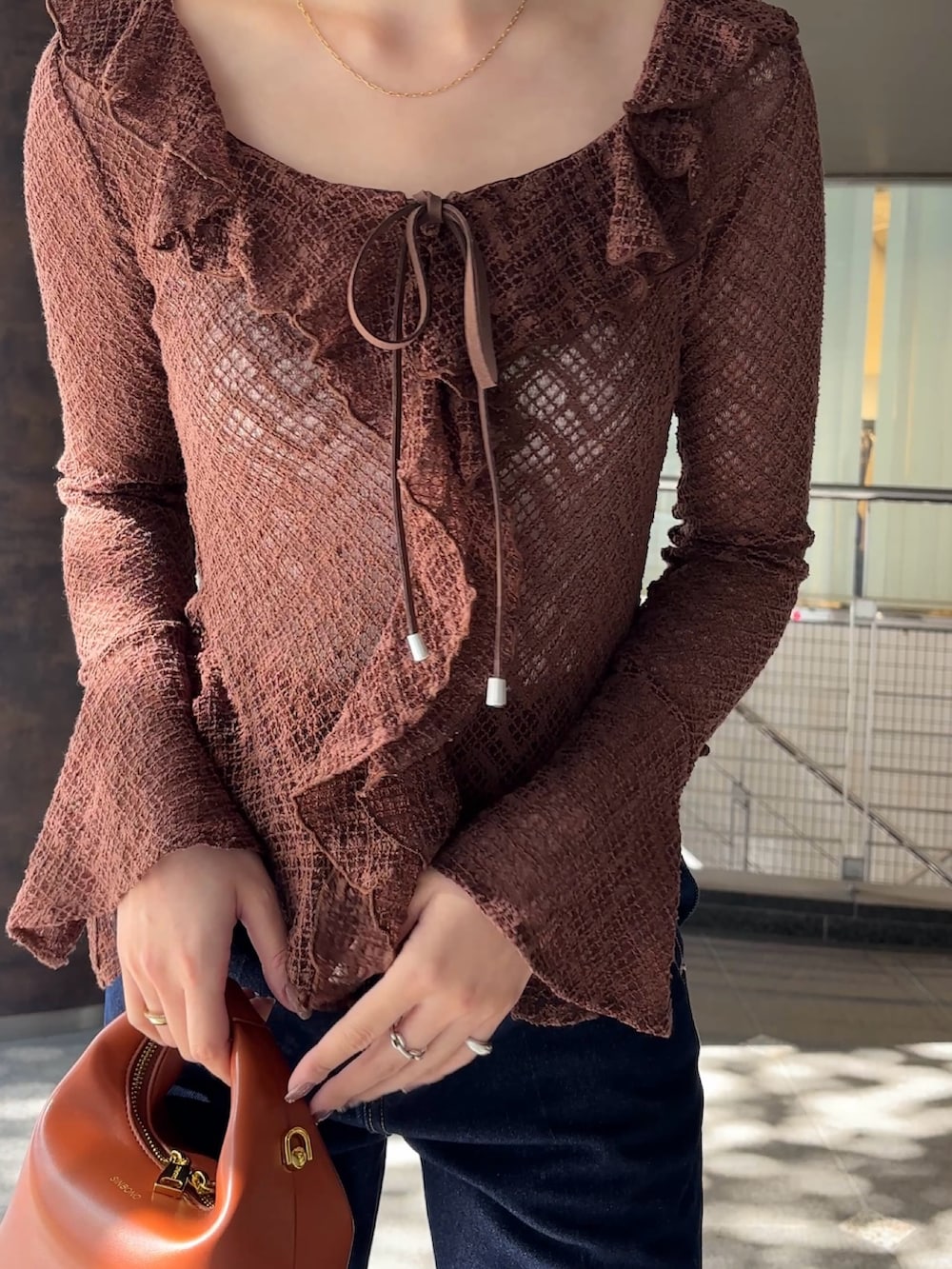 ブラウン系のシャツ/ブラウス、シルバー系のパンプス、ブラウン系のハンドバッグを着用したレディースの冬コーディネートの4枚目の写真