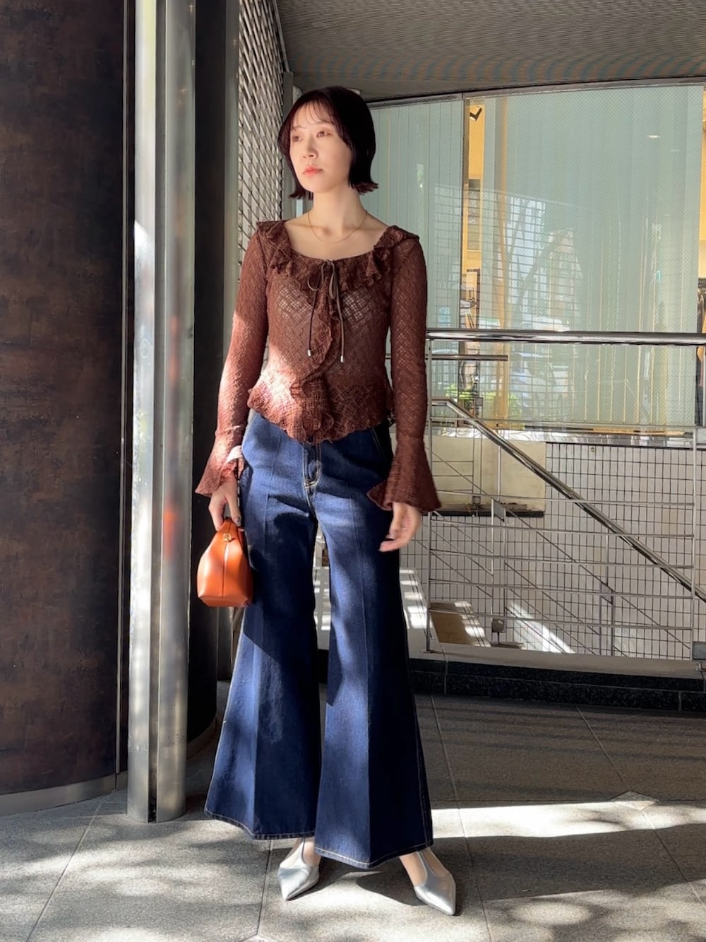 ブラウン系のシャツ/ブラウス、シルバー系のパンプス、ブラウン系のハンドバッグを着用したレディースの冬コーディネートの2枚目の写真