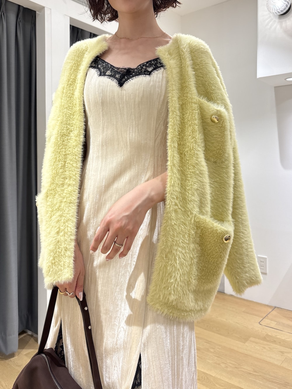 ホワイト系のワンピース、イエロー系のカーディガン/ボレロ、ブラウン系のハンドバッグを着用したレディースの秋コーディネートの5枚目の写真