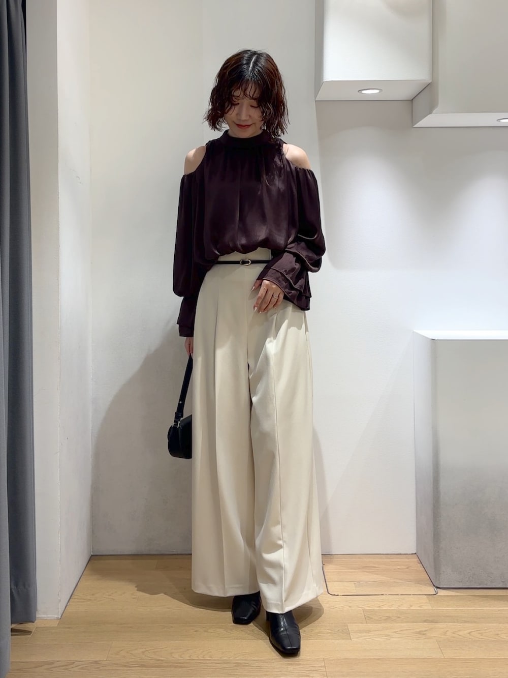 ブラウン系のシャツ/ブラウス、ホワイト系のその他パンツ、ブラック系のハンドバッグを着用したレディースの秋コーディネートの2枚目の写真