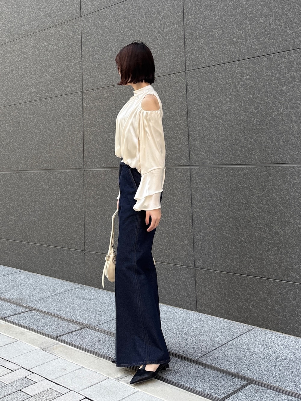 ホワイト系のシャツ/ブラウス、ホワイト系のハンドバッグ、ベージュ系のテーラードジャケットを着用したレディースの春コーディネートの5枚目の写真