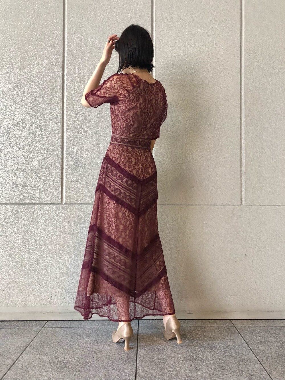 レッド系のドレス、ベージュ系のパンプス、ベージュ系のクラッチバッグを着用したレディースの秋コーディネートの4枚目の写真