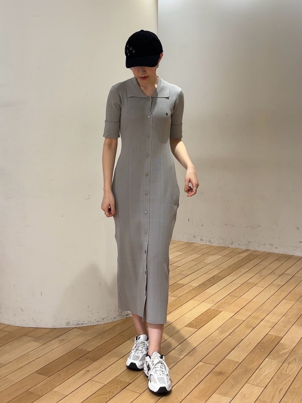 グレー系のワンピース、ブラック系のキャップを着用したレディースの春コーディネートの3枚目の写真