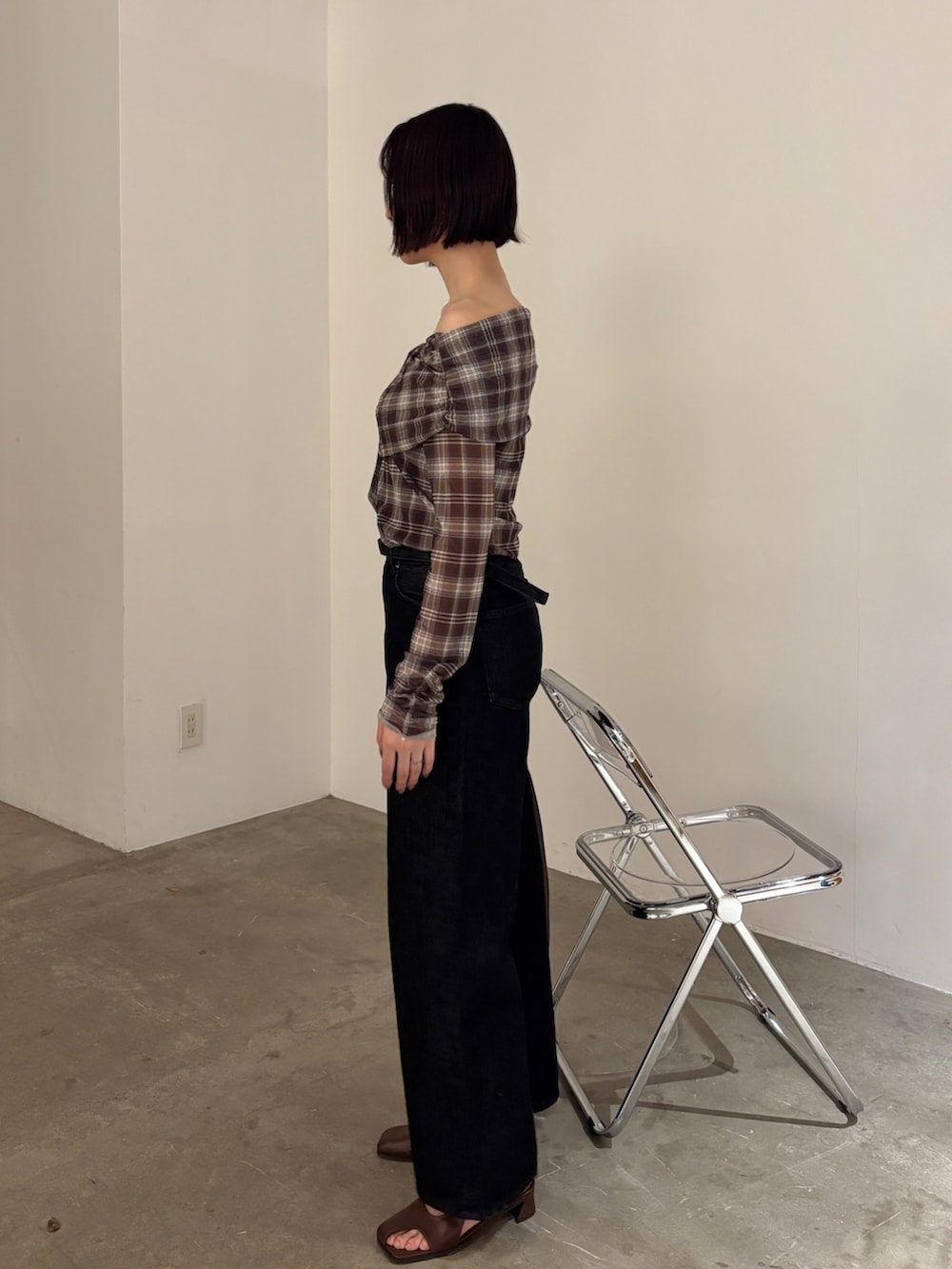 ブラウン系のシャツ/ブラウス、ブラウン系のハンドバッグ、ブラック系のデニムパンツを着用したレディースの春コーディネートの2枚目の写真