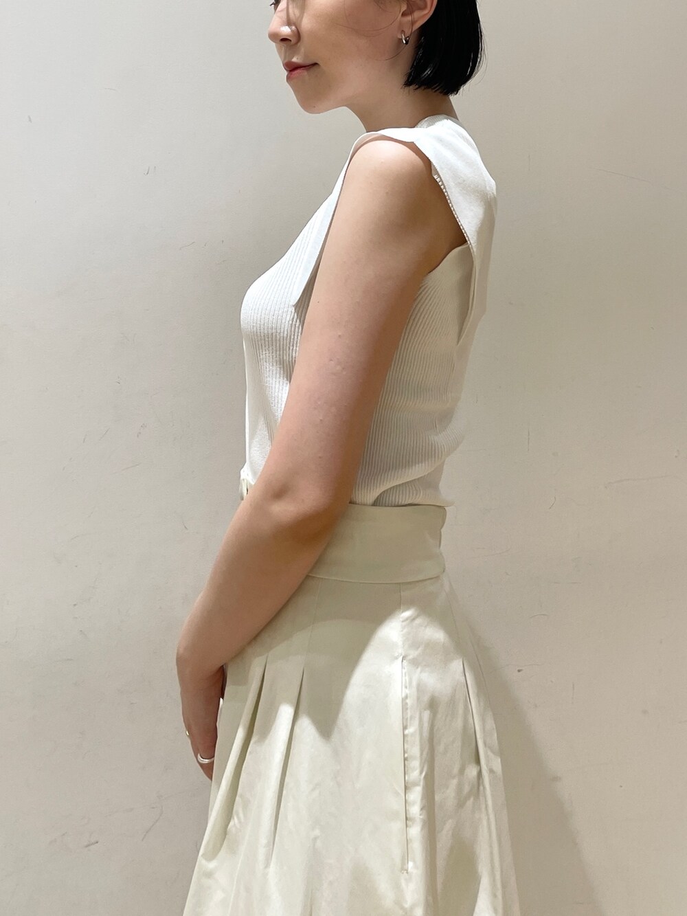 ホワイト系のニット/セーター、ホワイト系のスカート、ホワイト系のハンドバッグを着用したレディースの夏コーディネートの7枚目の写真