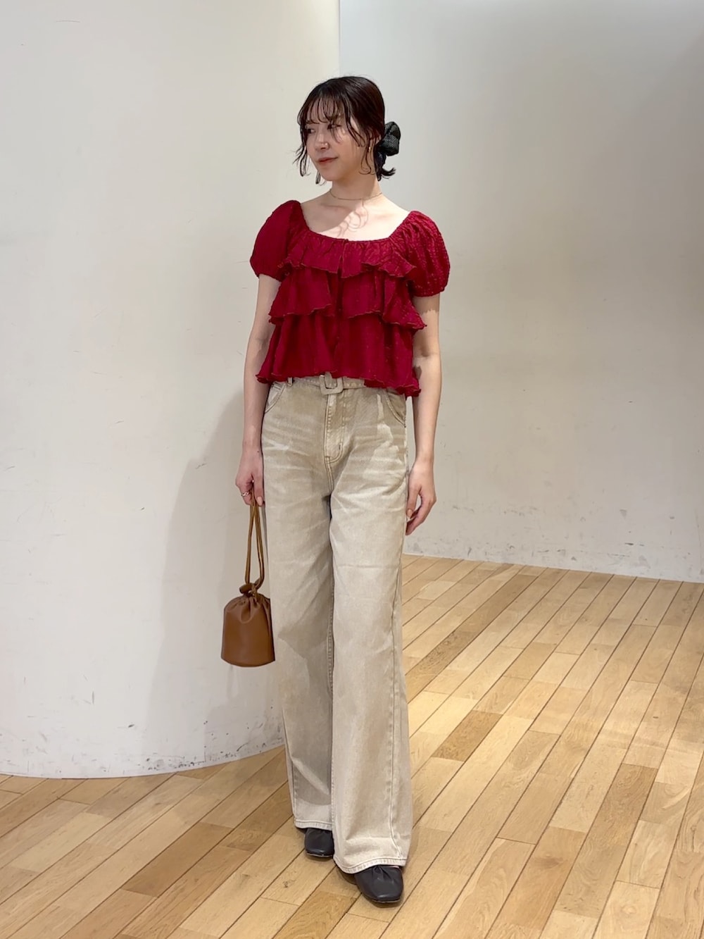 ベージュ系のデニムパンツ、レッド系のシャツ/ブラウス、イエロー系のハンドバッグを着用したレディースの夏コーディネートの2枚目の写真