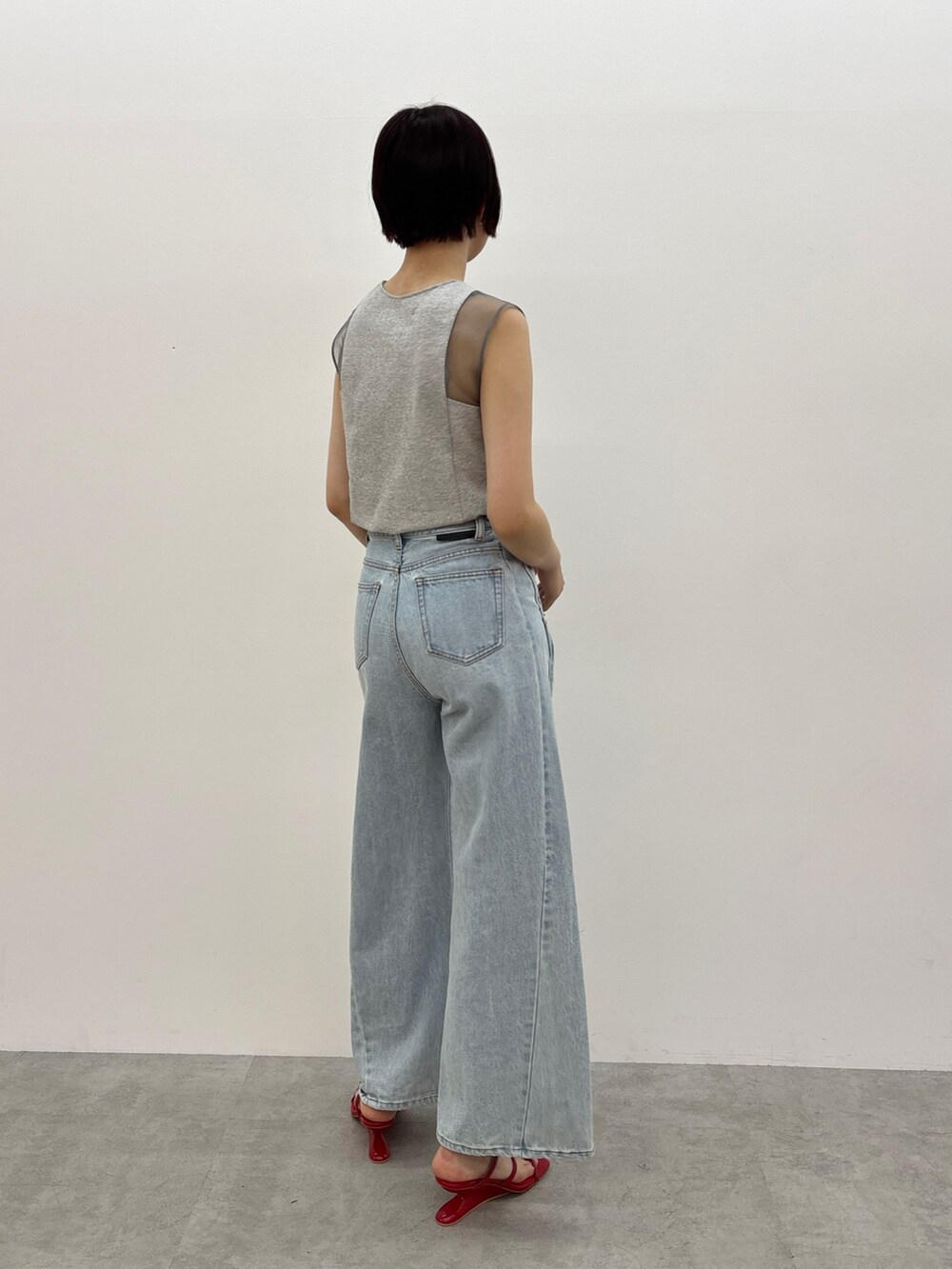 ブルー系のデニムパンツ、レッド系のサンダル、グレー系のTシャツ/カットソーを着用したレディースの春コーディネートの3枚目の写真