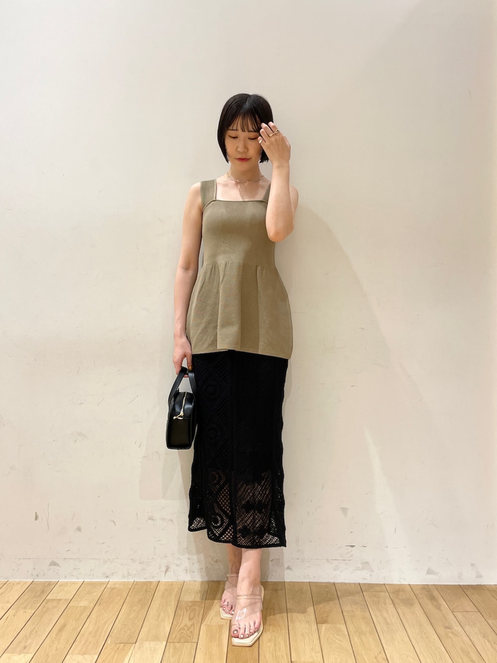 ブラック系のスカート、ブラック系のショルダーバッグ、その他のサンダルを着用したレディースの夏コーディネートの2枚目の写真