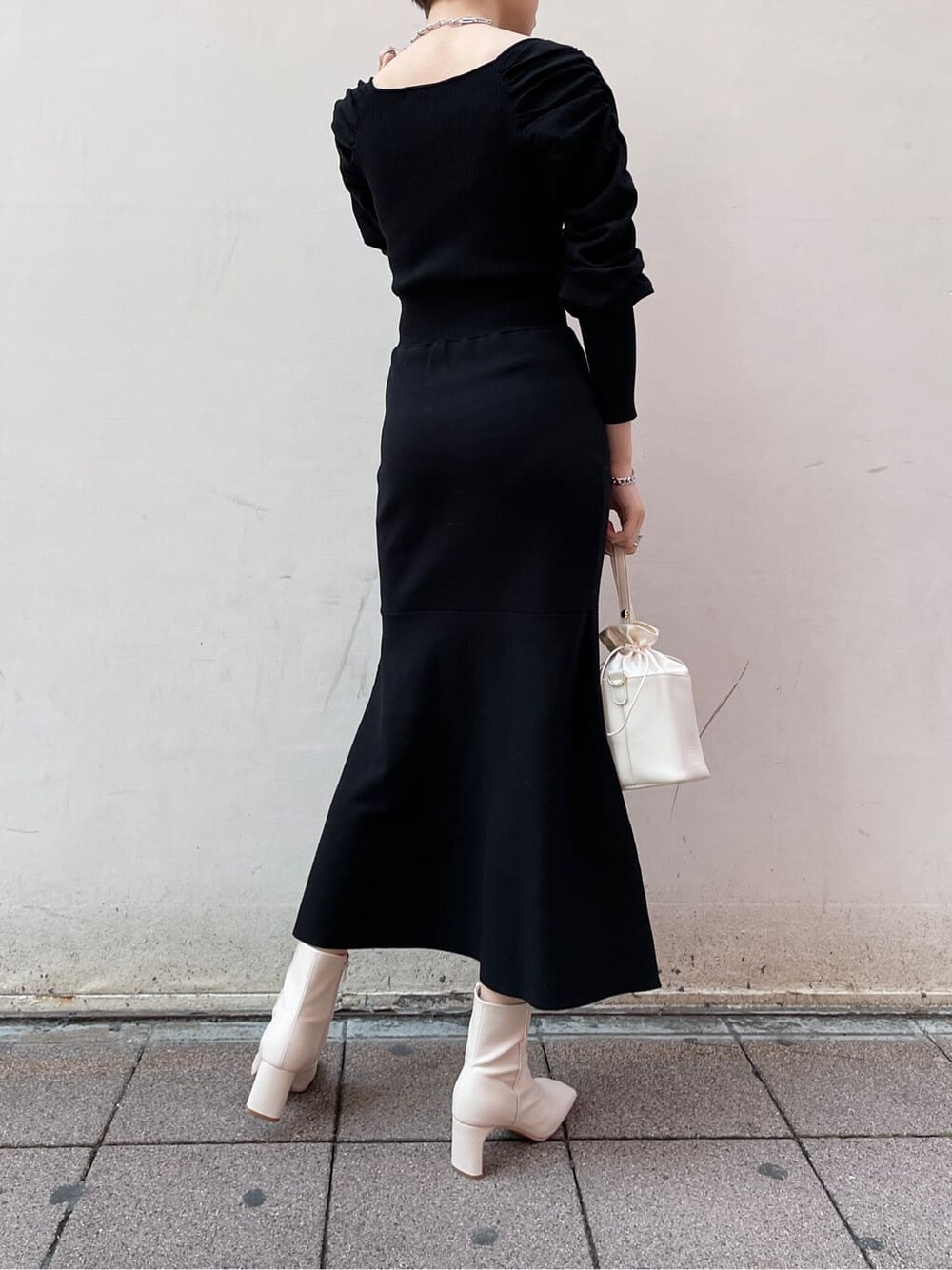 ブラック系のワンピース、ホワイト系のハンドバッグ、ホワイト系のその他シューズを着用したレディースの冬コーディネートの4枚目の写真