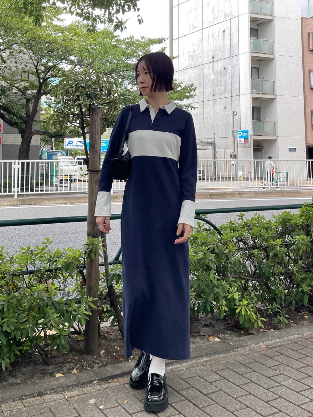 ブラック系のショルダーバッグ、ブルー系のワンピース、ブラック系のローファーを着用したレディースの秋コーディネートの2枚目の写真