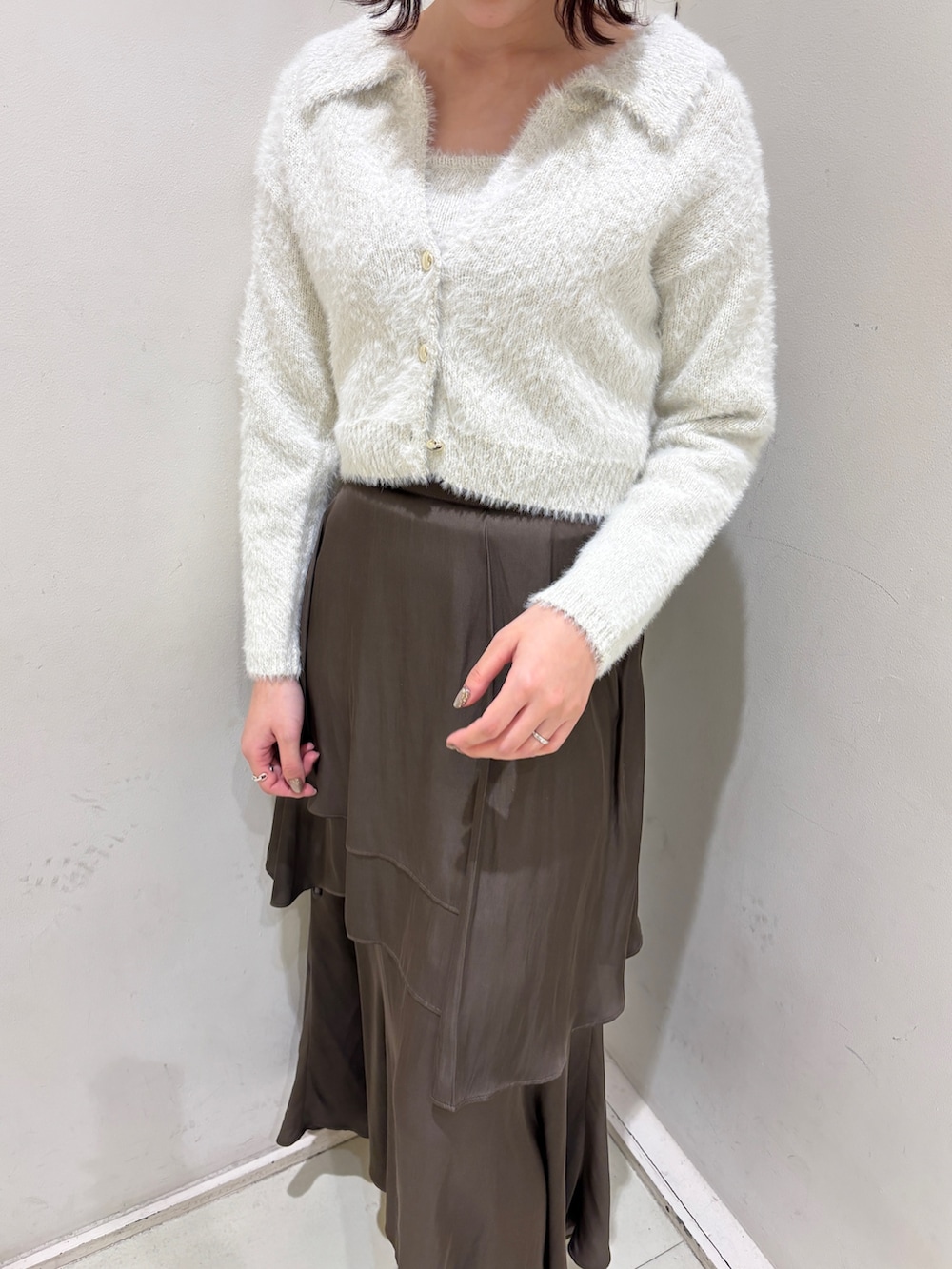 ブラウン系のスカート、ホワイト系のアンサンブルを着用したレディースの冬コーディネートの3枚目の写真