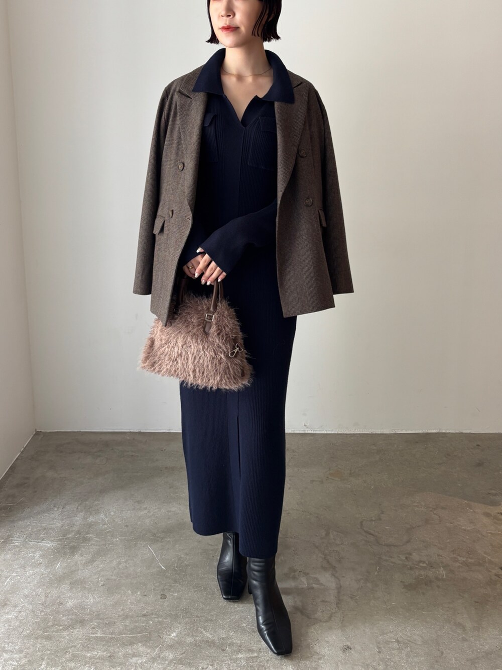 ブルー系のワンピース、ブラウン系のテーラードジャケット、ブラウン系のボストンバッグを着用したレディースの秋コーディネートの2枚目の写真