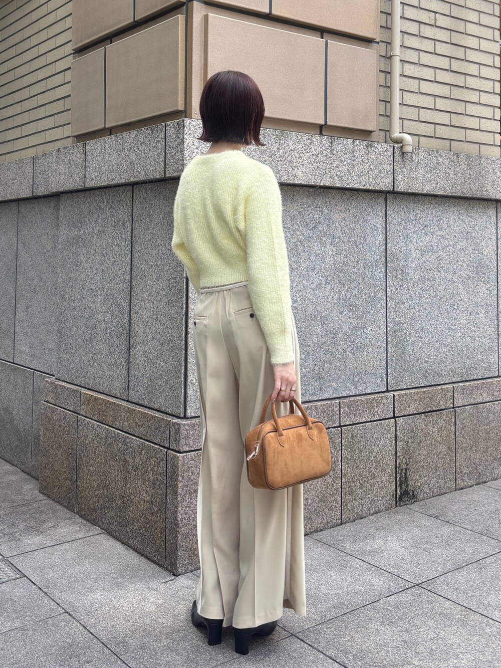 ベージュ系のその他パンツ、イエロー系のカーディガン/ボレロ、イエロー系のハンドバッグを着用したレディースの秋コーディネートの3枚目の写真