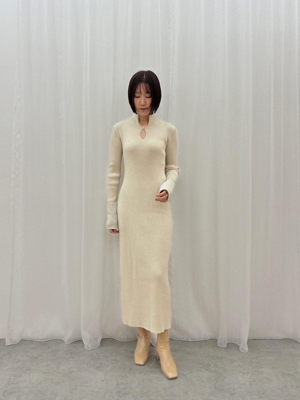 ホワイト系のワンピース、シルバー系のネックレスを着用したレディースの秋コーディネートの2枚目の写真