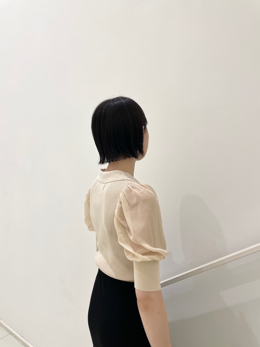 ブラック系のスカート、ホワイト系のニット/セーター、ブラック系のハンドバッグを着用したレディースの夏コーディネートの7枚目の写真