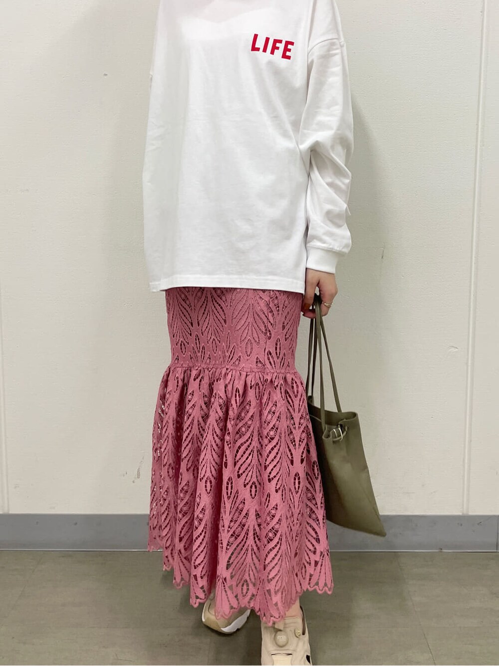 ピンク系のスカート、ホワイト系のTシャツ/カットソー、ベージュ系のスニーカーを着用したレディースの春コーディネートの5枚目の写真