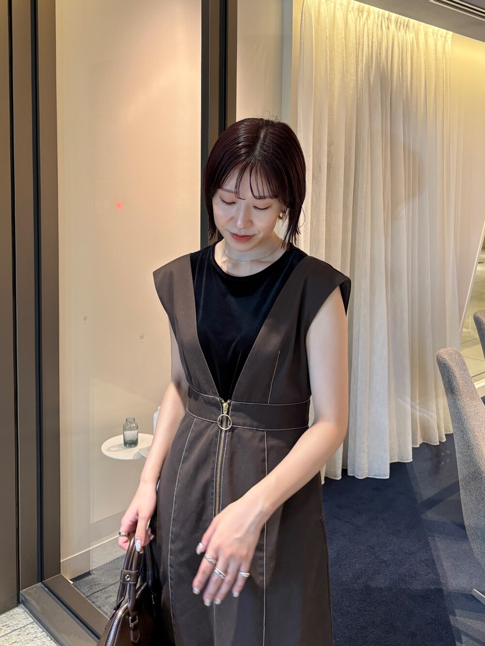 ブラウン系のジャンパースカート、ブラウン系のパンプス、ブラウン系のボストンバッグを着用したレディースの夏コーディネートの5枚目の写真