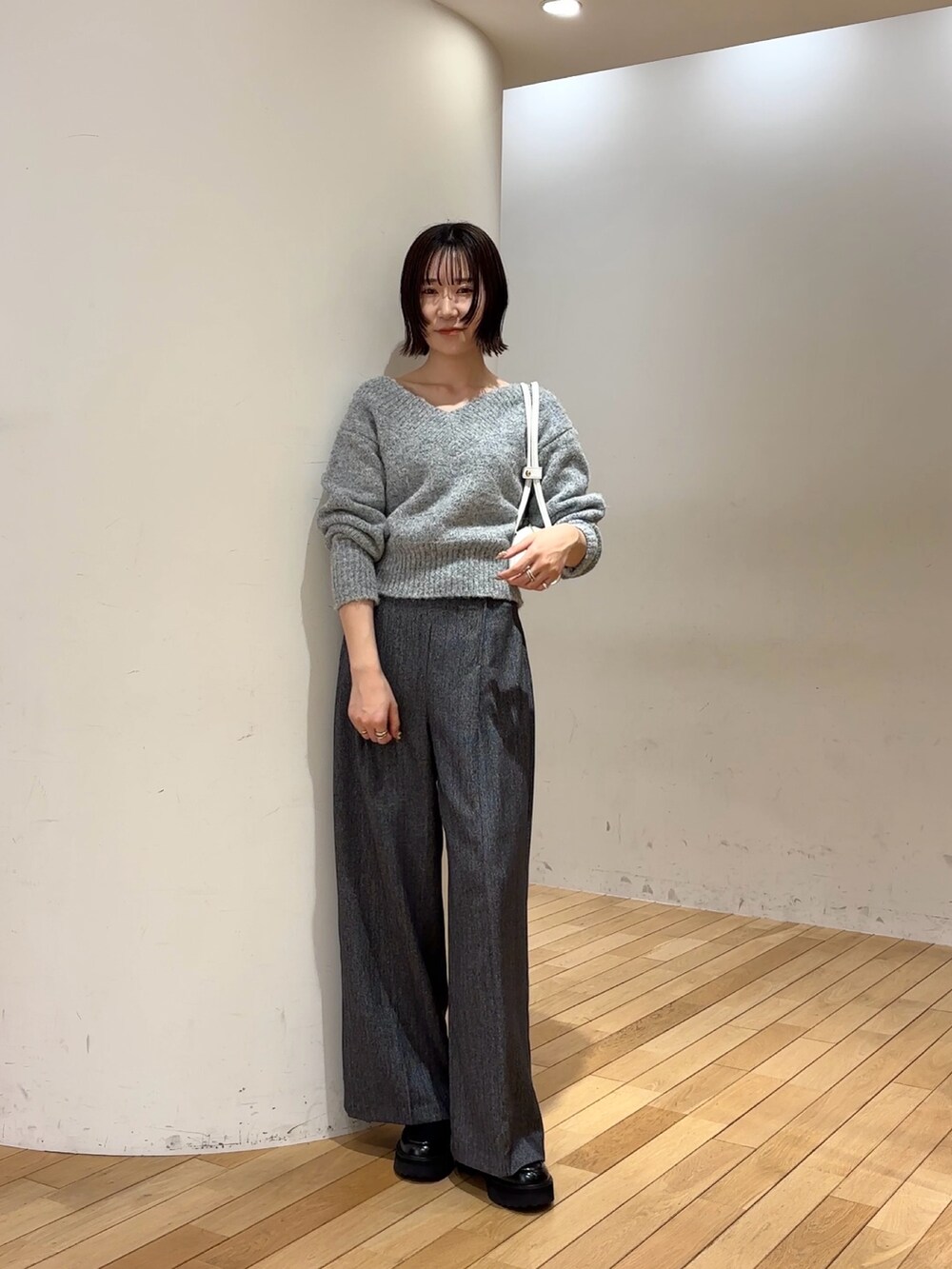 グレー系のその他パンツ、グレー系のニット/セーター、ホワイト系のショルダーバッグを着用したレディースの冬コーディネートの2枚目の写真