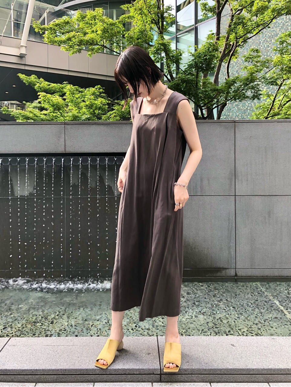 イエロー系のサンダル、グレー系のワンピース、シルバー系のネックレスを着用したレディースの夏コーディネートの4枚目の写真