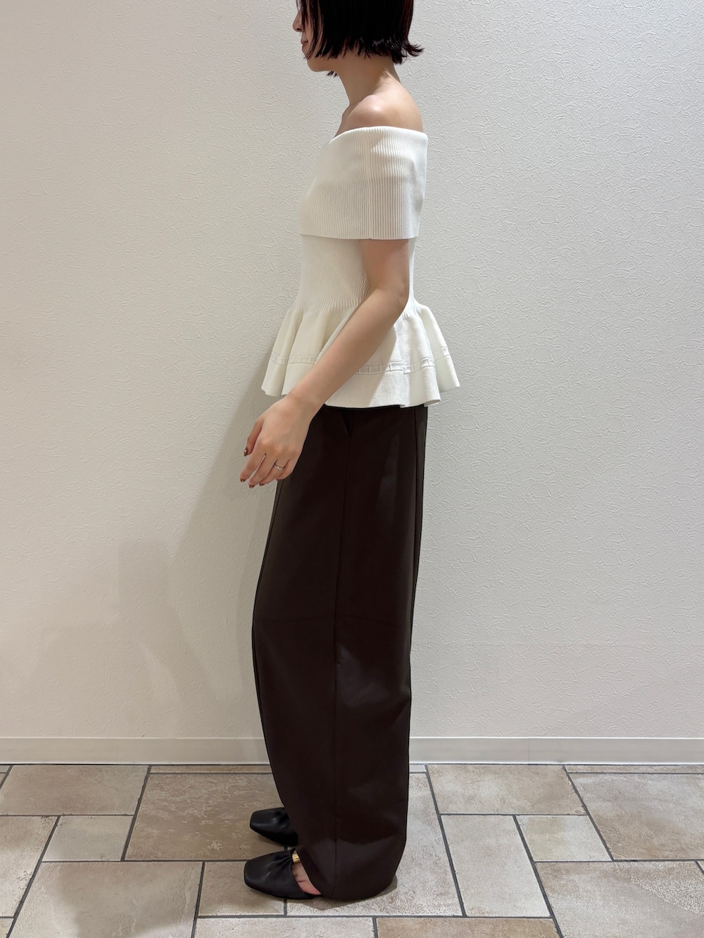 ブラウン系のその他パンツ、ホワイト系のニット/セーター、イエロー系のハンドバッグを着用したレディースの夏コーディネートの2枚目の写真