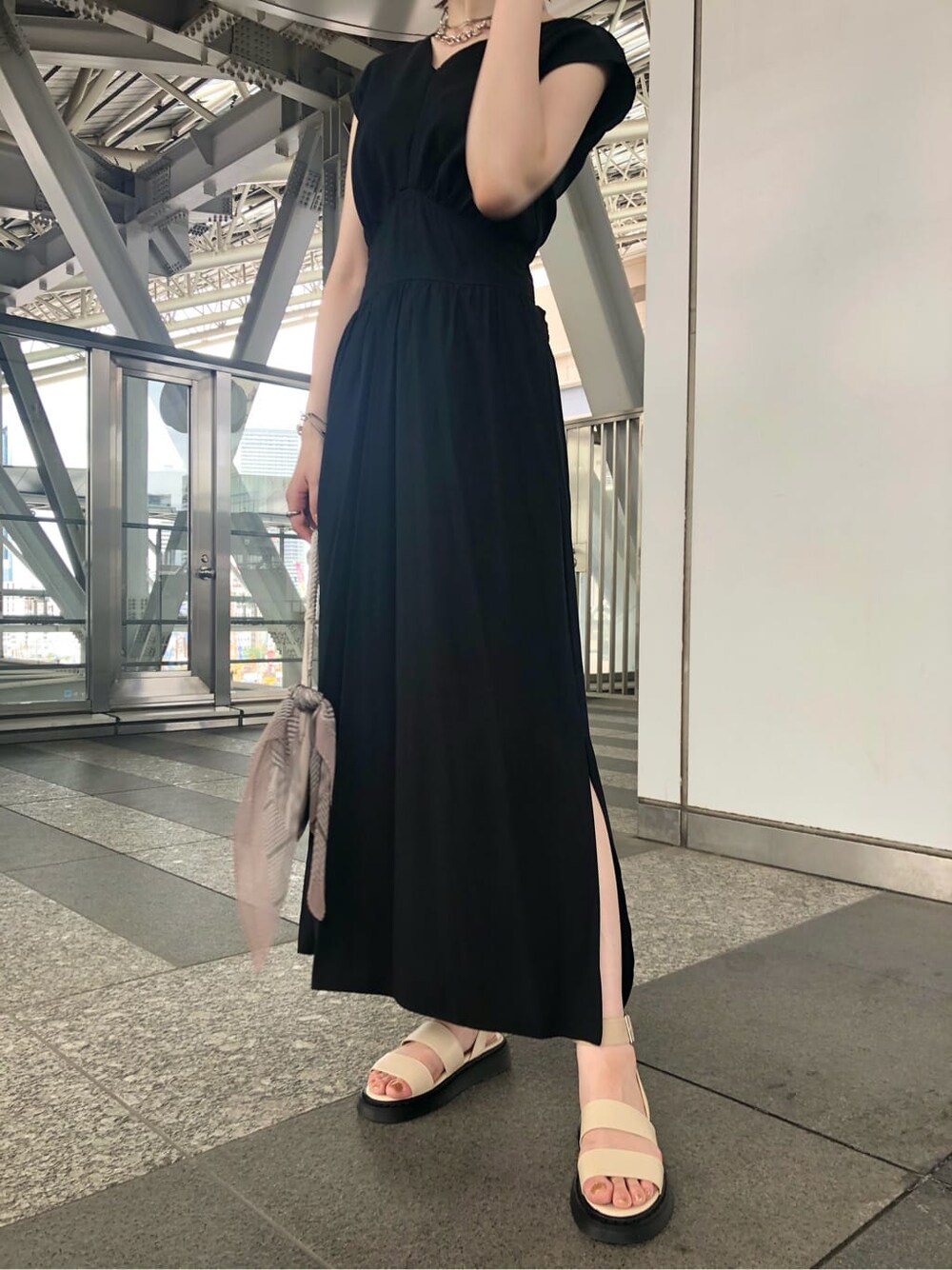 ホワイト系のショルダーバッグ、ブラック系のワンピース、ホワイト系のサンダルを着用したレディースの夏コーディネートの3枚目の写真