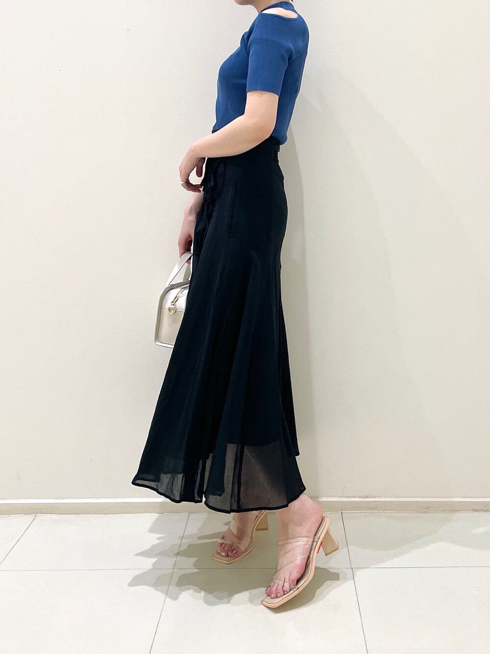 ブラック系のスカート、ホワイト系のショルダーバッグ、その他のサンダルを着用したレディースの夏コーディネートの5枚目の写真