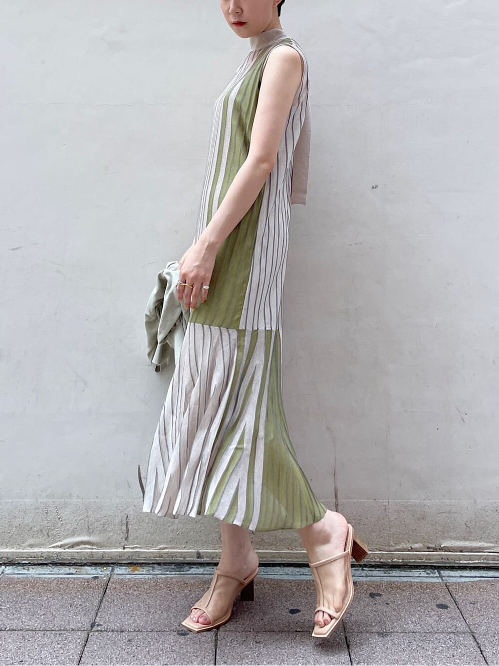 グリーン系のワンピース、グリーン系のカーディガン/ボレロ、ベージュ系のサンダルを着用したレディースの夏コーディネートの2枚目の写真