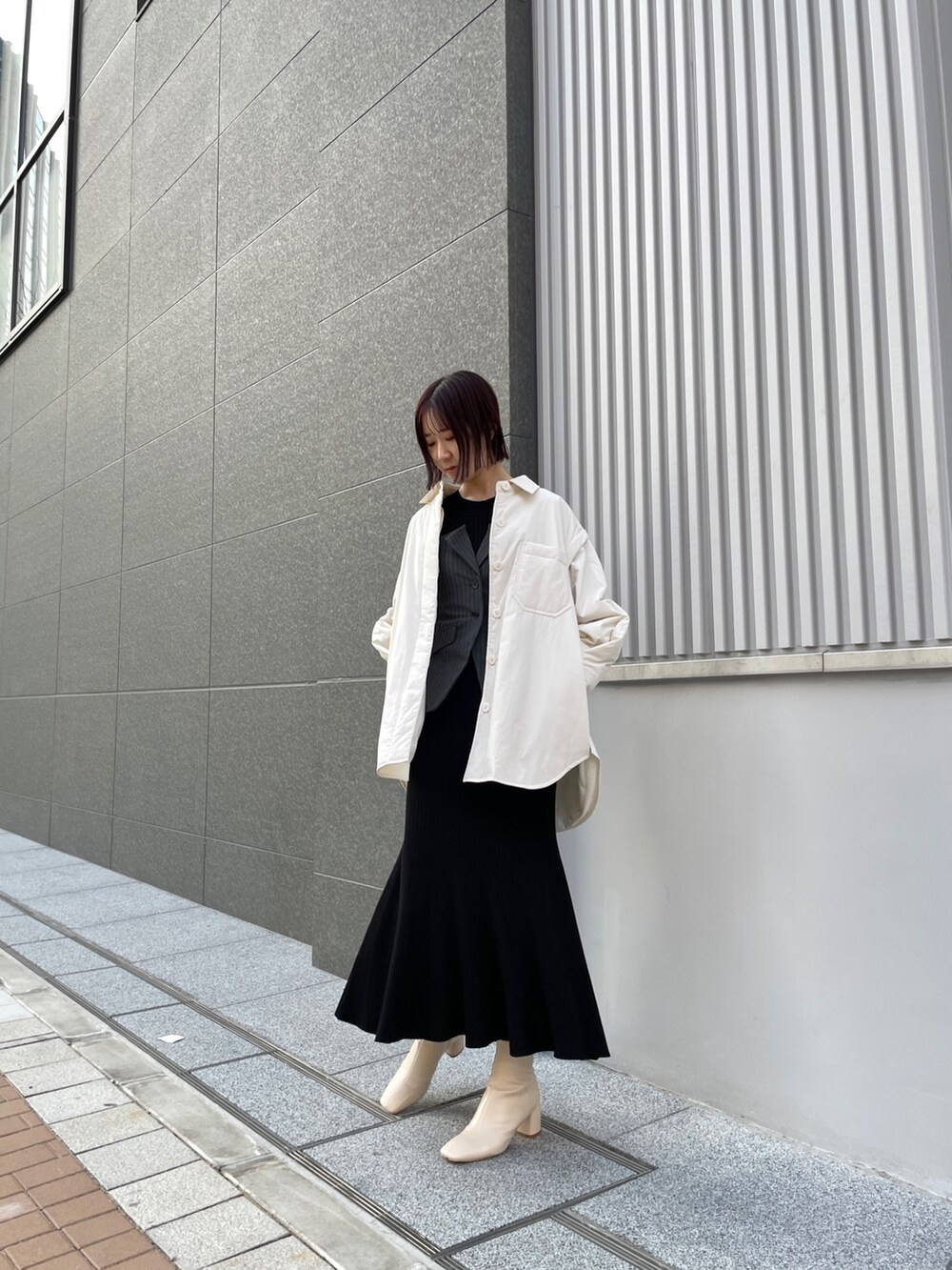 ホワイト系のブーツ、ブラック系のワンピース、ホワイト系のブルゾンを着用したレディースの冬コーディネートの6枚目の写真