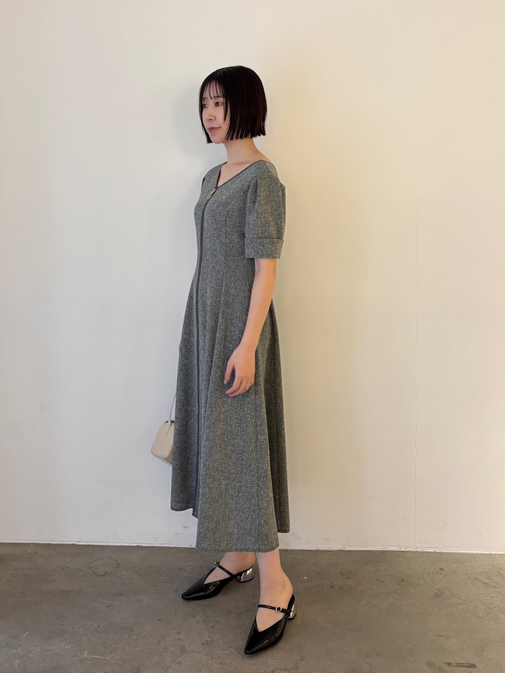 ブラック系のワンピース、ブラック系のパンプスを着用したレディースの春コーディネートの2枚目の写真