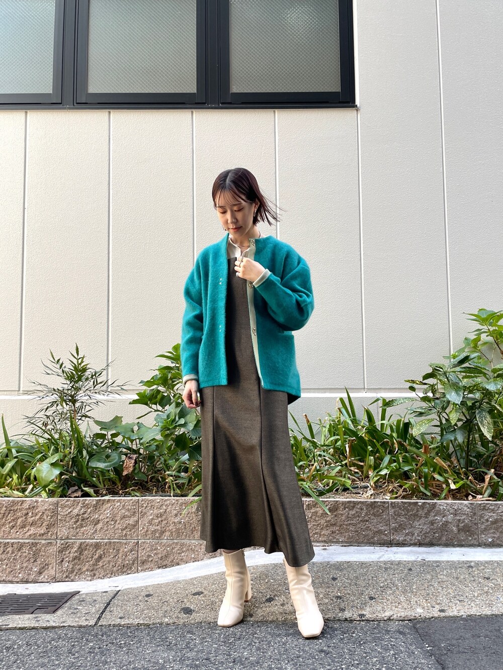 ブラウン系のワンピース、ブルー系のショルダーバッグ、ホワイト系のブーツを着用したレディースの秋コーディネートの8枚目の写真